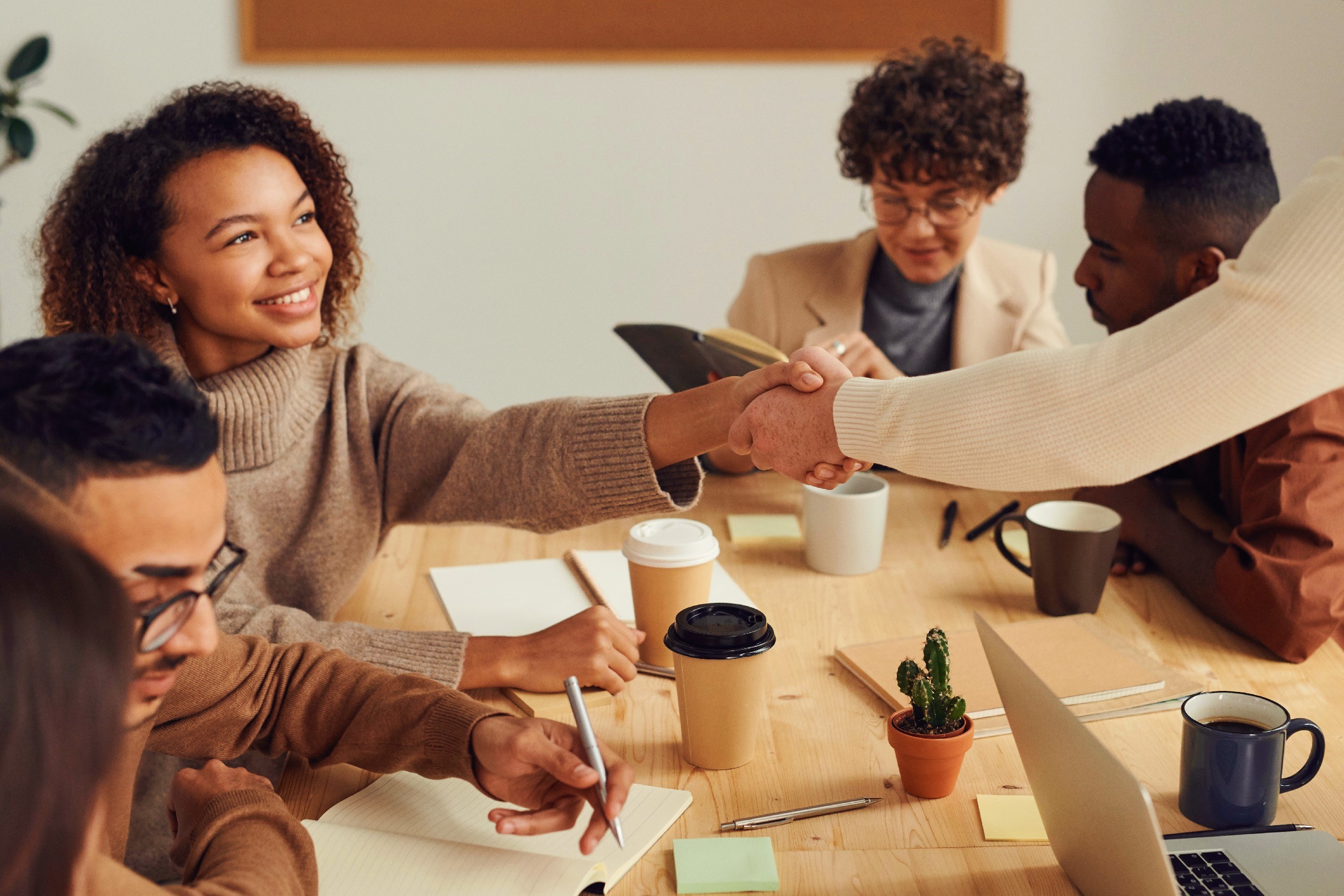 A table of peers. two shake hands